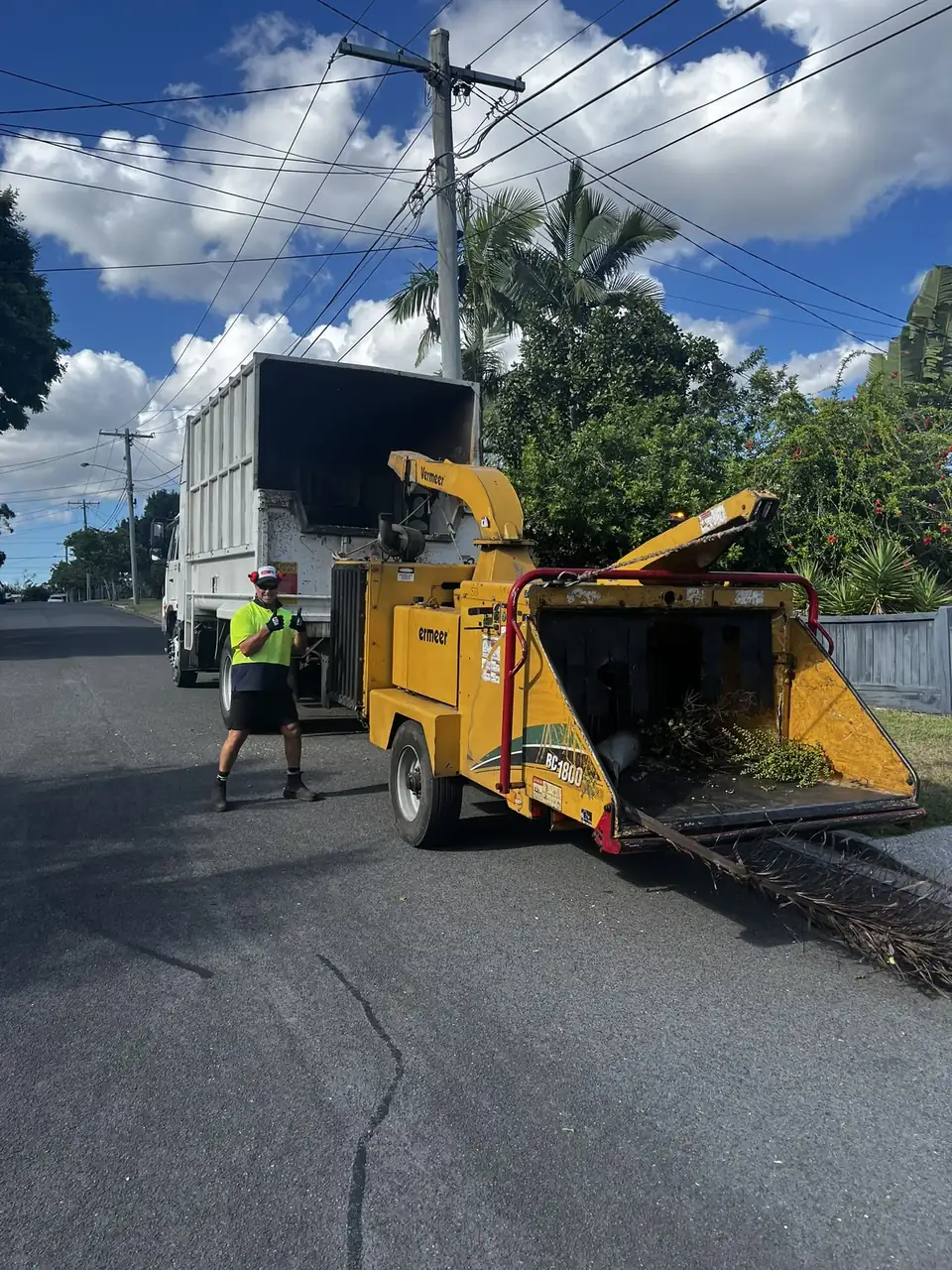 Dan's Tree Experts wood chipper and tipper truck set up on a Brisbane street